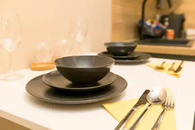 a table with two black bowls and wine glasses at Golden Dove Luxury Aparts in Brussels