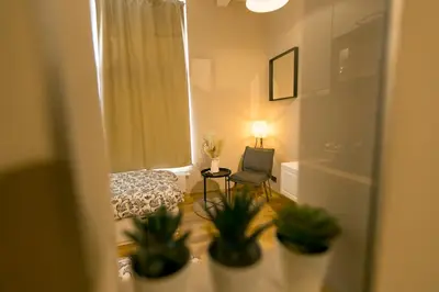 a room with a bed and a chair and a window at Golden Dove Luxury Aparts in Brussels