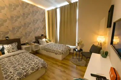 a hotel room with two beds and a desk at Golden Dove Luxury Aparts in Brussels