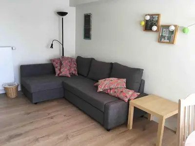 a living room with a gray couch and a table at 'het T-huisje' volledig ingerichte studio in Leuven