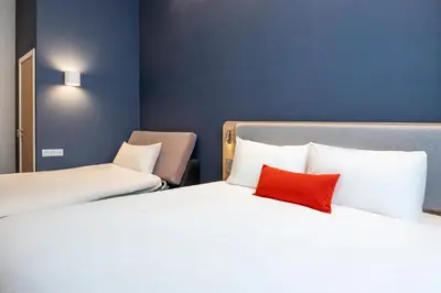 two beds in a hotel room with a red pillow at Holiday Inn Express Antwerp - City Centre by IHG in Antwerp