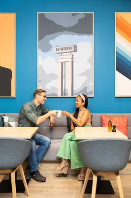 a man and a woman sitting on a couch at Holiday Inn Express Antwerp - City Centre by IHG in Antwerp