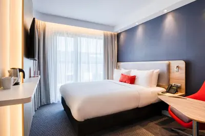 a hotel room with a large bed and a desk at Holiday Inn Express Antwerp - City Centre by IHG in Antwerp