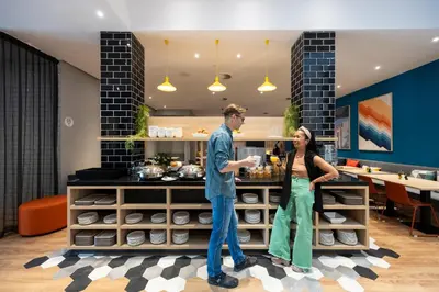 a man and a woman standing next to a counter at Holiday Inn Express Antwerp - City Centre by IHG in Antwerp