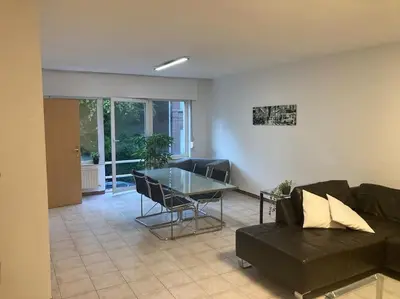 a living room with a couch and a glass table at Superbe appartement lumineux et spacieux in Antwerp