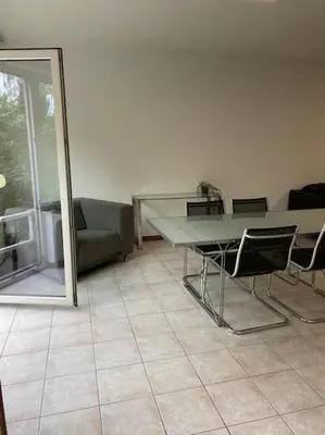 a room with a table and chairs and a couch at Superbe appartement lumineux et spacieux in Antwerp