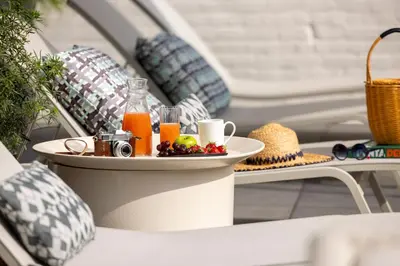 a tray of juice and fruit on a table on a patio at L-Avenue in Brussels