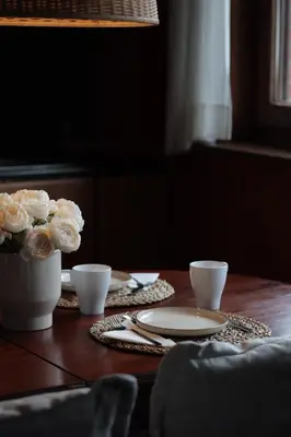 a table with a vase of flowers and two cups at Spacious Villa in Dilbeek with Private Garden, Ideal for Families & Business in Dilbeek