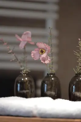 three vases with pink flowers in them on a table at Spacious Villa in Dilbeek with Private Garden, Ideal for Families & Business in Dilbeek