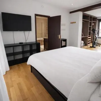 a bedroom with a large white bed and a flat screen tv at Spacious Villa in Dilbeek with Private Garden, Ideal for Families & Business in Dilbeek