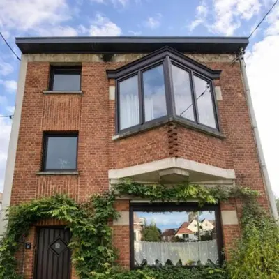 a red brick building with a large window at Spacious Villa in Dilbeek with Private Garden, Ideal for Families & Business in Dilbeek