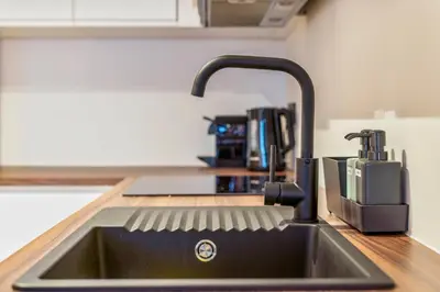a kitchen sink with a faucet on a counter at Mooie vernieuwde Duplex in hartje Gent , Patershol in Ghent