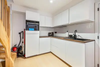 a kitchen with white cabinets and a sink at Mooie vernieuwde Duplex in hartje Gent , Patershol in Ghent