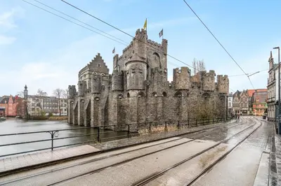 an old castle with train tracks in front of it at Mooie vernieuwde Duplex in hartje Gent , Patershol in Ghent