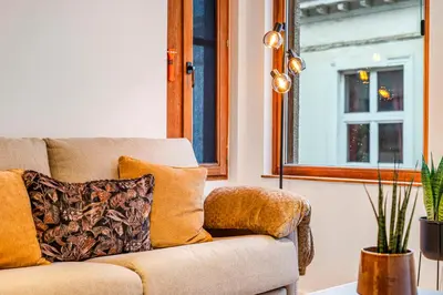 a living room with a couch and a window at Mooie vernieuwde Duplex in hartje Gent , Patershol in Ghent