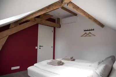 a room with two white beds in a attic at Vakantiewoning Den Appel in Dendermonde