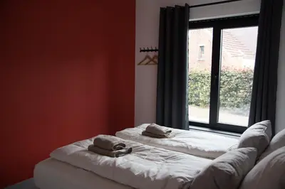 two towels sitting on a bed in front of a window at Vakantiewoning Den Appel in Dendermonde