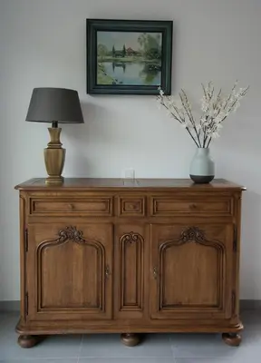 a wooden cabinet with a lamp and a vase on top at Vakantiewoning Den Appel in Dendermonde
