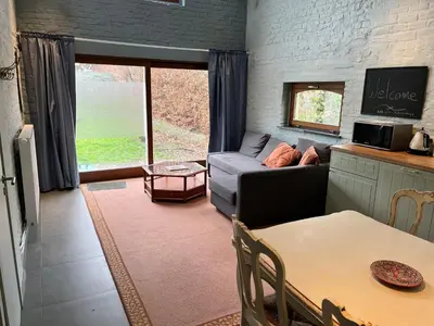 a living room with a couch and a table at Cosy little house in Kraainem