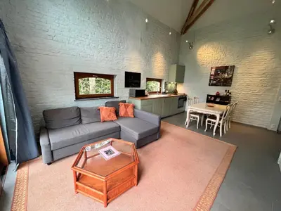 a living room with a couch and a table at Cosy little house in Kraainem