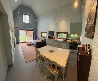 a kitchen and living room with a table and chairs at Cosy little house in Kraainem