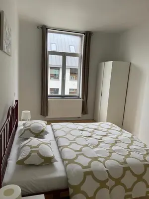 a bedroom with a large bed and a large window at Modern Apartment Third Floor in Brussels