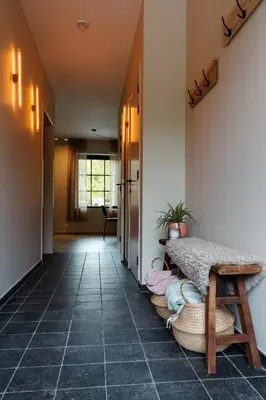 a hallway with a bench and a table at 'De Zandrug' vakantiehoeve - B&B in Stekene