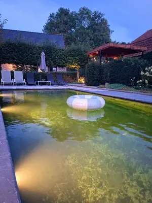 a swimming pool with a raft in the water at 'De Zandrug' vakantiehoeve - B&B in Stekene
