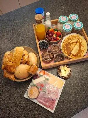 a table with a tray of breakfast foods and drinks at 'De Zandrug' vakantiehoeve - B&B in Stekene