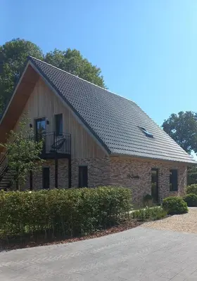 a large brick building with a gambrel roof at 'De Zandrug' vakantiehoeve - B&B in Stekene