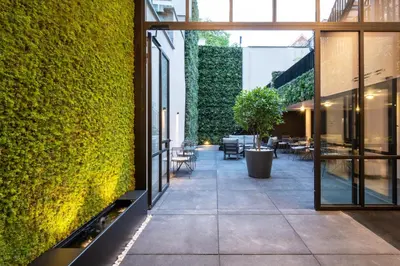 an internal courtyard of a building with a green wall at ONE TWO FOUR - Hotel & Spa in Ghent