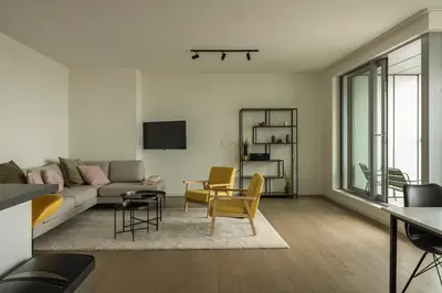 a living room with a couch and a table at UNIEK appartement - mooiste en hoogste uitzicht op Antwerpen! - incl gratis parking in Antwerp