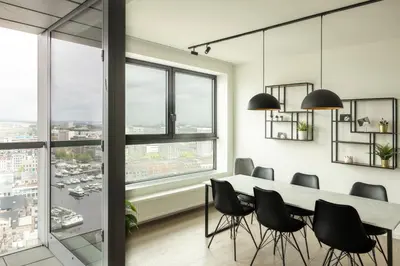 a dining room with a table and chairs and large windows at UNIEK appartement - mooiste en hoogste uitzicht op Antwerpen! - incl gratis parking in Antwerp
