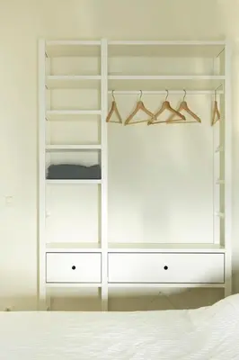 a white wardrobe in a bedroom with a bed at UNIEK appartement - mooiste en hoogste uitzicht op Antwerpen! - incl gratis parking in Antwerp