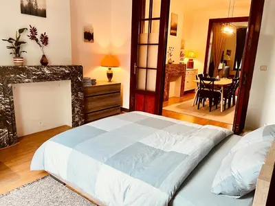 a bedroom with a large bed and a dining room at Cozy, comfortable apt, well located - EU ULB VUB in Brussels