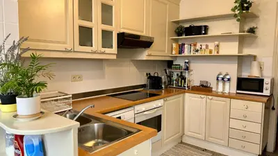 a kitchen with white cabinets and a sink at Cozy, comfortable apt, well located - EU ULB VUB in Brussels