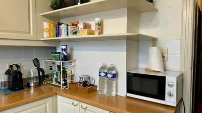 a kitchen counter with a microwave and bottles of water at Cozy, comfortable apt, well located - EU ULB VUB in Brussels