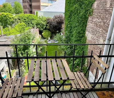 a wooden bench sitting on top of a balcony at Cozy, comfortable apt, well located - EU ULB VUB in Brussels