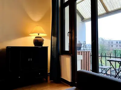 a lamp on top of a dresser in a room with a window at Cozy, comfortable apt, well located - EU ULB VUB in Brussels