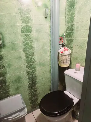 a bathroom with a black toilet and a green tiled wall at Lockable room center in Antwerp