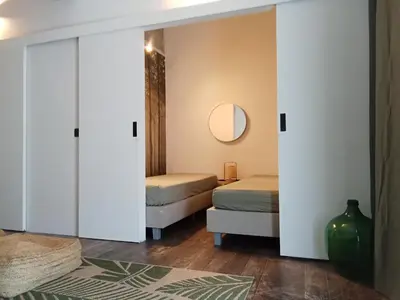 a bedroom with two beds and a mirror at Quest house in the city in Ghent