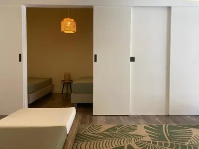 a bedroom with white sliding doors and a bed at Quest house in the city in Ghent