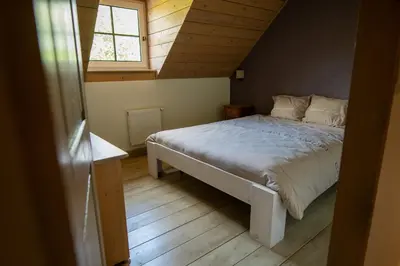 a bedroom with a bed in a attic with a window at Bed and Breakfast Paellepelhoeve in Ninove