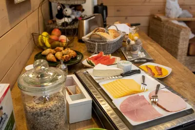a kitchen counter with food on a table with meat and cheese at Bed and Breakfast Paellepelhoeve in Ninove
