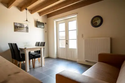 a living room with a table and chairs and a window at Bed and Breakfast Paellepelhoeve in Ninove