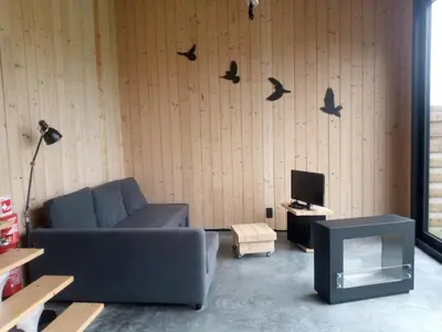 a living room with a couch and birds on the wall at Station 25A in Duffel