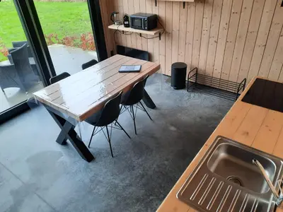 a table and chairs in a kitchen with a sink at Station 25A in Duffel