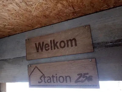 a sign that says wisdom is hanging from the ceiling at Station 25A in Duffel
