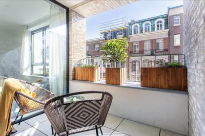 a balcony with two chairs and a window with plants at Sunny haven in Antwerp