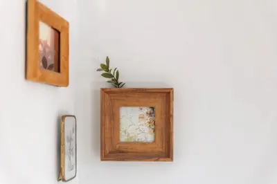 a wooden picture frame on a white wall with pictures at Sunny haven in Antwerp
